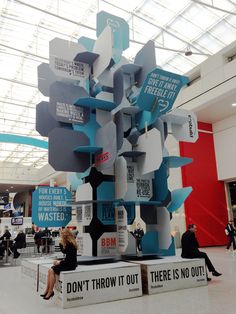 there is a large sculpture in the middle of a building with people sitting on it