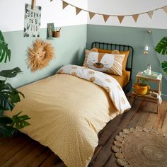 a bedroom decorated in yellow and green with a lion head on the wall above the bed