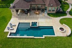 an aerial view of a house with a swimming pool and patio in the foreground