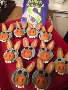 cupcakes made to look like animals are on a red tray next to a book