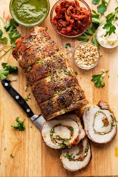 meatloaf with vegetables and sauces on a wooden cutting board next to it