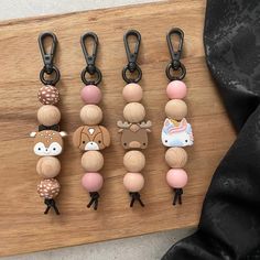 four wooden key chains with animals on them