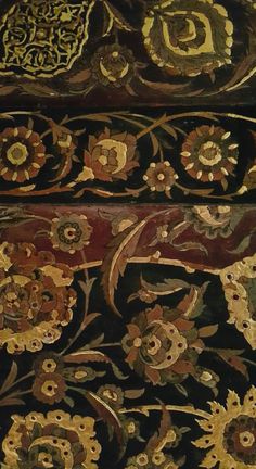 an intricately decorated piece of wood with flowers and leaves on the bottom half of it