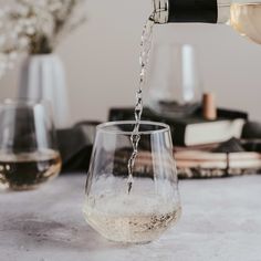 wine being poured into a glass on a table