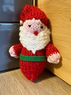 a knitted santa clause doll hanging on the door