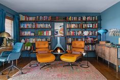 a living room filled with furniture and a fire place in the middle of a bookshelf