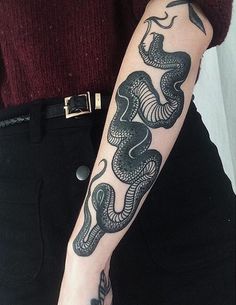 a woman with a snake tattoo on her arm