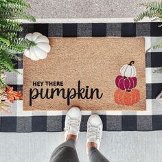 someone standing in front of a door mat with the words hey there pumpkin on it