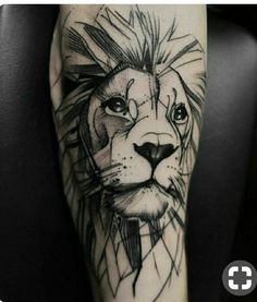 a black and white tattoo of a lion on the left leg, with its head turned to the right