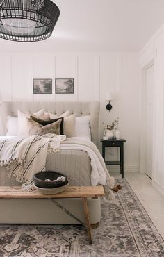 a bed sitting in a bedroom on top of a wooden table next to a rug