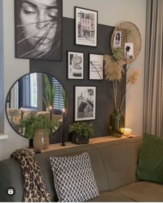 a living room filled with furniture and pictures on the wall above it's mirror