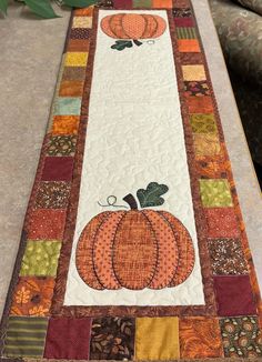 a quilted table runner with pumpkins on it