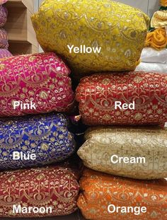 many different colored pillows stacked on top of each other