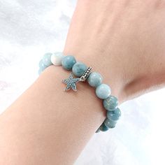 Experience the calming energy of the ocean with our Ocean Starfish Larimar Beaded Bracelet. This beautiful bracelet features a Larimar beaded strand, known for its soothing and healing properties, and is adorned with a charming starfish pendant charm made of solid 925 sterling silver. Add a touch of elegance and serenity to your wardrobe. Materials: Larimar, 925 sterling silver You can choose the option with the starfish charm or without the starfish charm. Jewelry Care: See more information about how to care for your jewelry here. Shipping Policy: Orders will be shipped within 1-3 business days. Economy shipping will take 7-14 days to arrive and standard shipping is 1- 4 days for U.S. orders. International shipping time is depended on the country and per shipping method. Shipping cost wil Turquoise Starfish Beaded Bracelets, Ocean-inspired, Ocean-inspired Turquoise Starfish Beaded Bracelets, Turquoise Beaded Bracelets With Starfish Charm, Ocean Starfish, Starfish Pendant, Silver Jewelry Earrings, Charm Beads, Handmade Fashion Jewelry, Screw Back Earrings