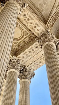 three pillars with intricate designs on them in front of a blue sky