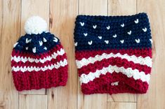 two crocheted hats with hearts on them sitting on a wooden floor next to each other