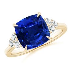 a blue sapphire and diamond ring with three diamonds on the side, set in yellow gold