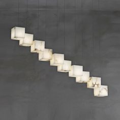 a long light fixture hanging from the side of a wall with cubes on it