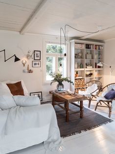 a living room filled with furniture and a fire place next to a book shelf full of books