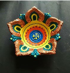 an intricately painted decorative object on a black surface