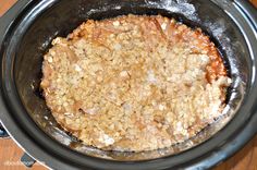 a crock pot filled with food on top of a wooden table