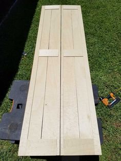 a wooden bench sitting on top of a green grass covered field next to a power tool