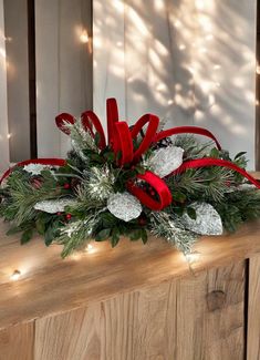 a christmas arrangement with red ribbon and greenery