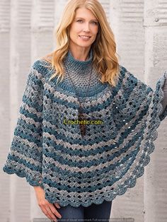 a woman wearing a blue and white crocheted ponchy with fringes