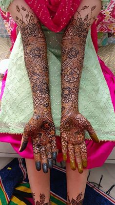 two hands with henna tattoos on them