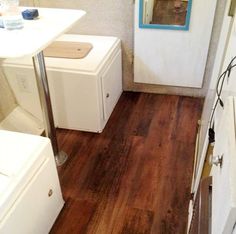 a small bathroom with wood floors and white appliances