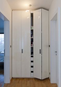 an empty room with white cupboards and wood floors