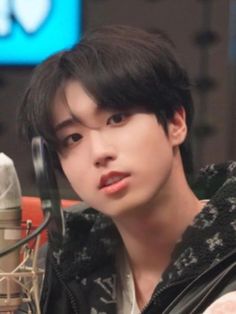 a young man sitting in front of a microphone