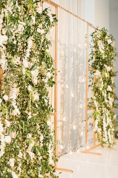 an arrangement of white flowers and greenery on display