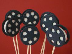 black and white cake pops with polka dot designs on them sitting in front of a red wall