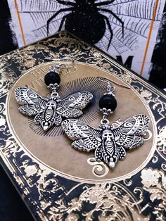 "💀This stunning goth jewelry is one of the best Halloween jewelry gifts for her!  Strut your stuff with these funky Deaths Head Moth Earrings. These creepy novelty earrings feature a pitted black lava bead and antiqued silver bead caps to perfectly compliment the moth! Whether you're a lover of Halloween earrings or just love great accessories, these cool Samhain earrings are perfect for you! These 2.5 inch goth earrings are available in a charm only option that measures 2 inches for a little l Moth Earrings, Deaths Head, Goth Things, Ear Stretching, Earrings Goth, Earrings Cool, Cool Insects, Deaths Head Moth, Diy Kandi