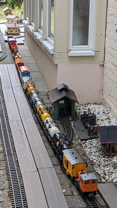 a toy train set on the tracks next to a building