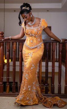 a woman in an orange dress standing on a balcony