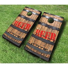 two wooden barrels with the word beer painted on them are laying in the grass next to each other