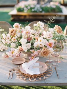 the table is set with pink and white flowers