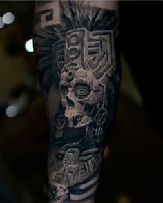 a man's arm with a skull and headdress tattoo design on it