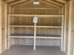 the inside of a building with wooden walls and shelves on each side that are covered in plywood planks