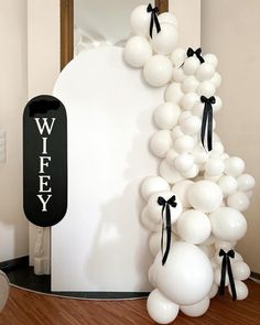 a bunch of balloons that are in front of a wall with the word w e y on it