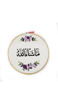 an embroidered wall hanging with the words in arabic and english, on it's side