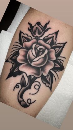 a black and white rose tattoo on the arm