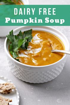 dairy free pumpkin soup in a white bowl with parsley on top and crackers next to it