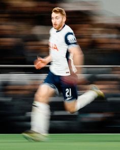 a blurry photo of a soccer player running with the ball in front of him