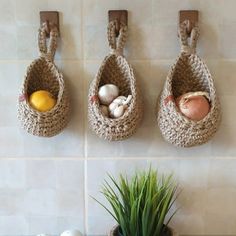 three baskets hanging on the wall with eggs in them