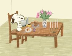 a snoopy dog sitting at a table reading a book with flowers in the background