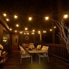 an outdoor deck with lights strung over it