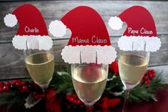 three wine glasses with santa hats on them